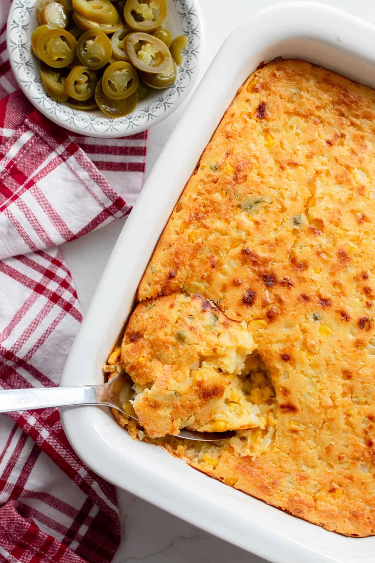 Delicious golden corn casserole in a rustic baking dish with a farmhouse setting