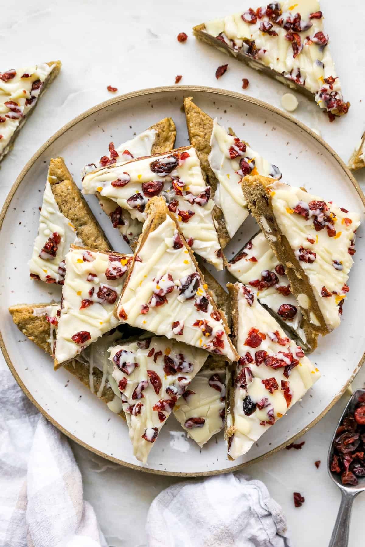 vibrant cranberry bliss bars with white chocolate drizzle on a rustic wooden board, festive, close-up