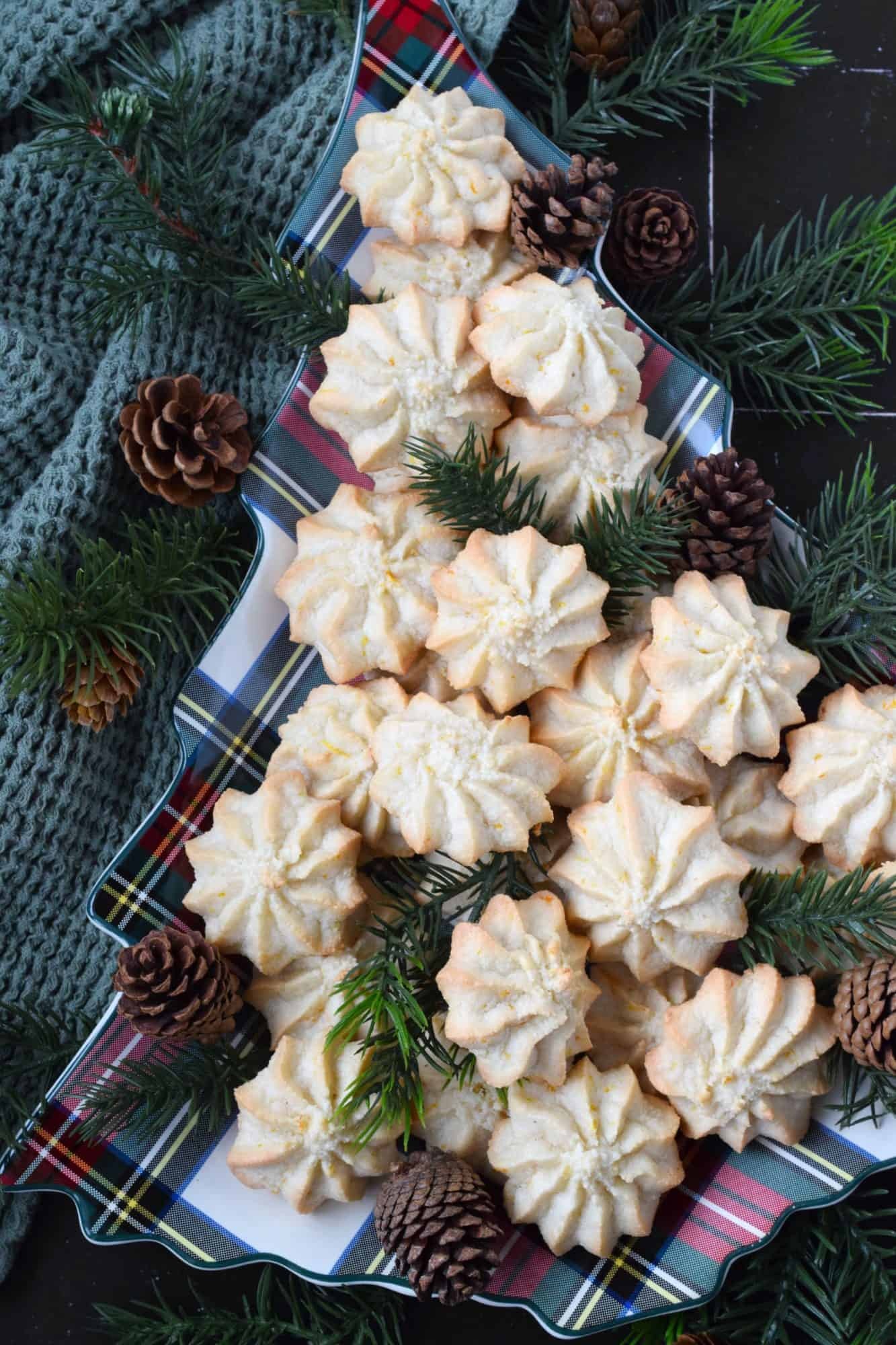 Elegant French tip almond cookies with glossy white icing, festive Christmas background, close-up, soft focus