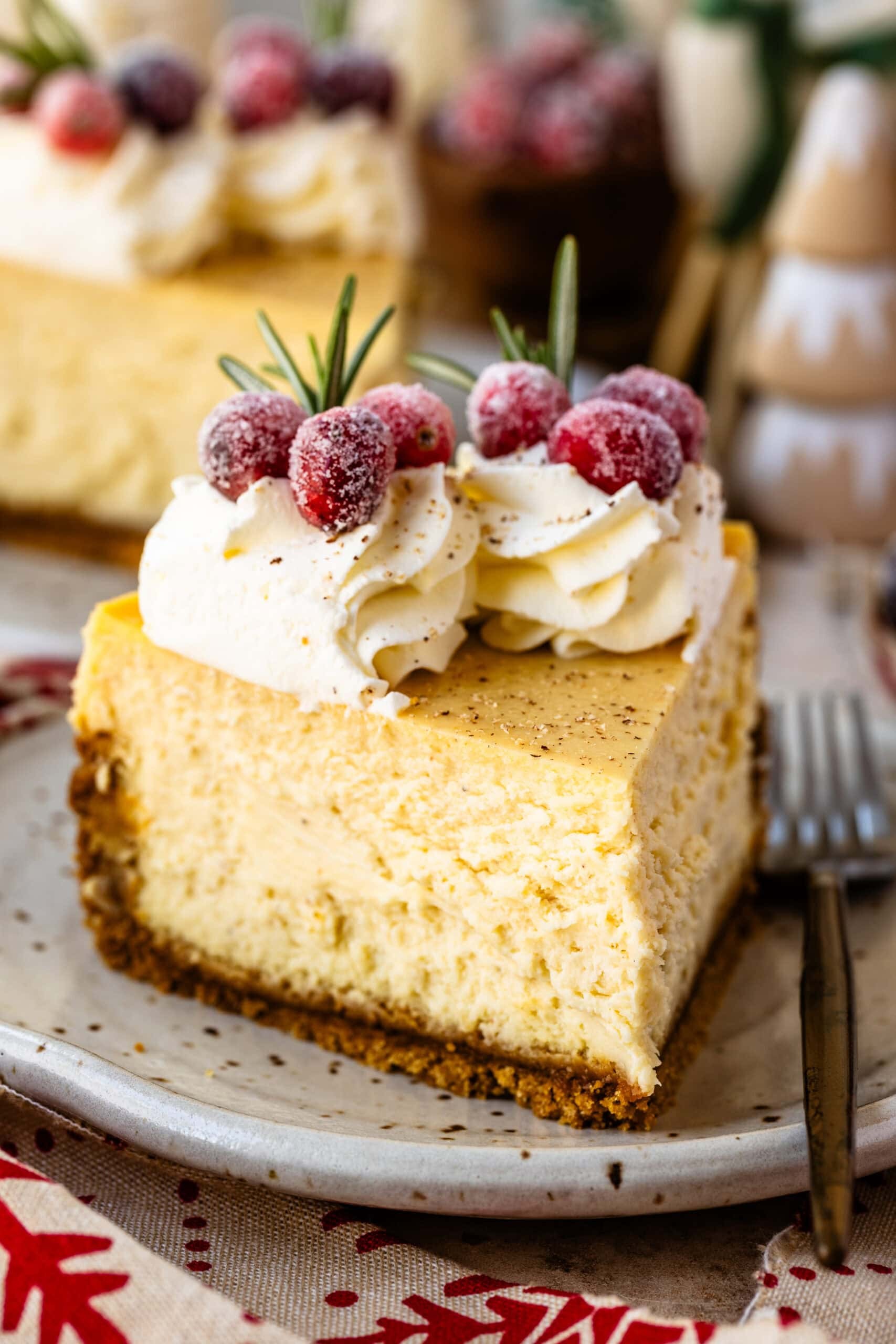 slice of eggnog cheesecake with whipped cream and nutmeg garnish