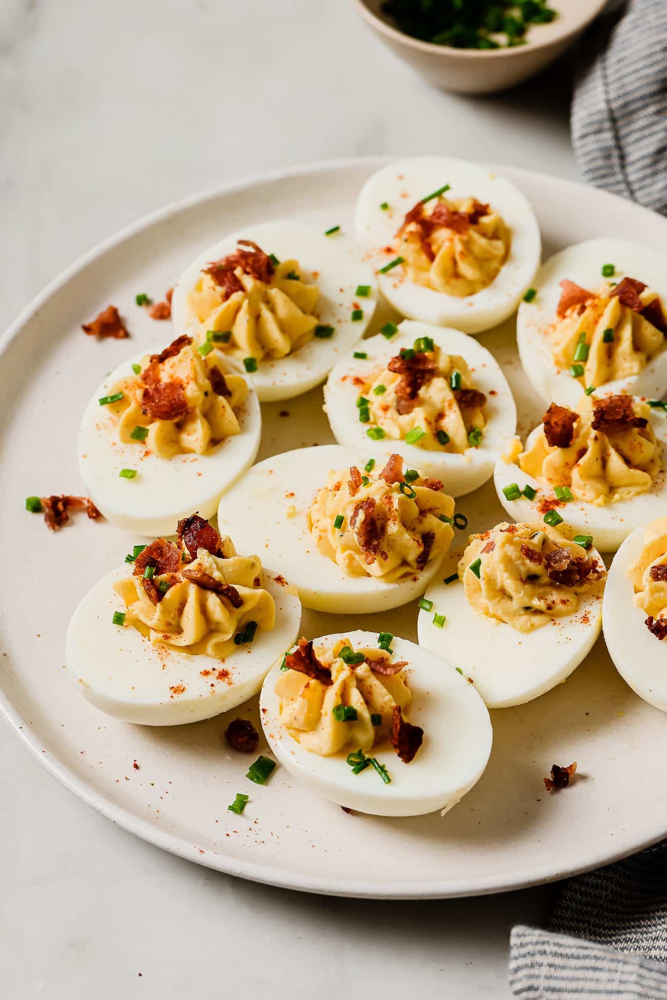 beautifully arranged deviled eggs with creamy mustard filling on a platter, garnished with paprika