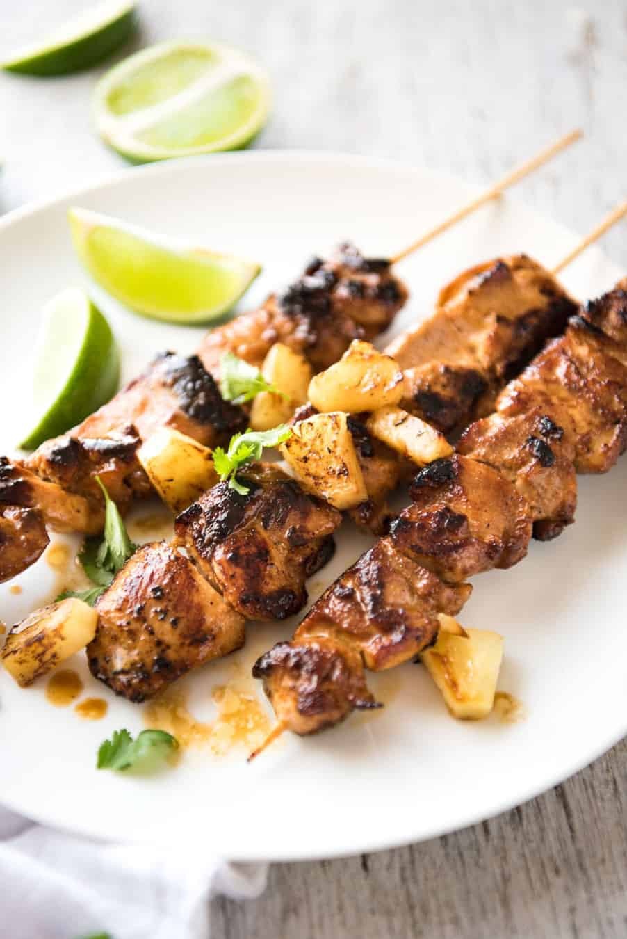 grilled pineapple and coconut chicken skewers on a tropical background