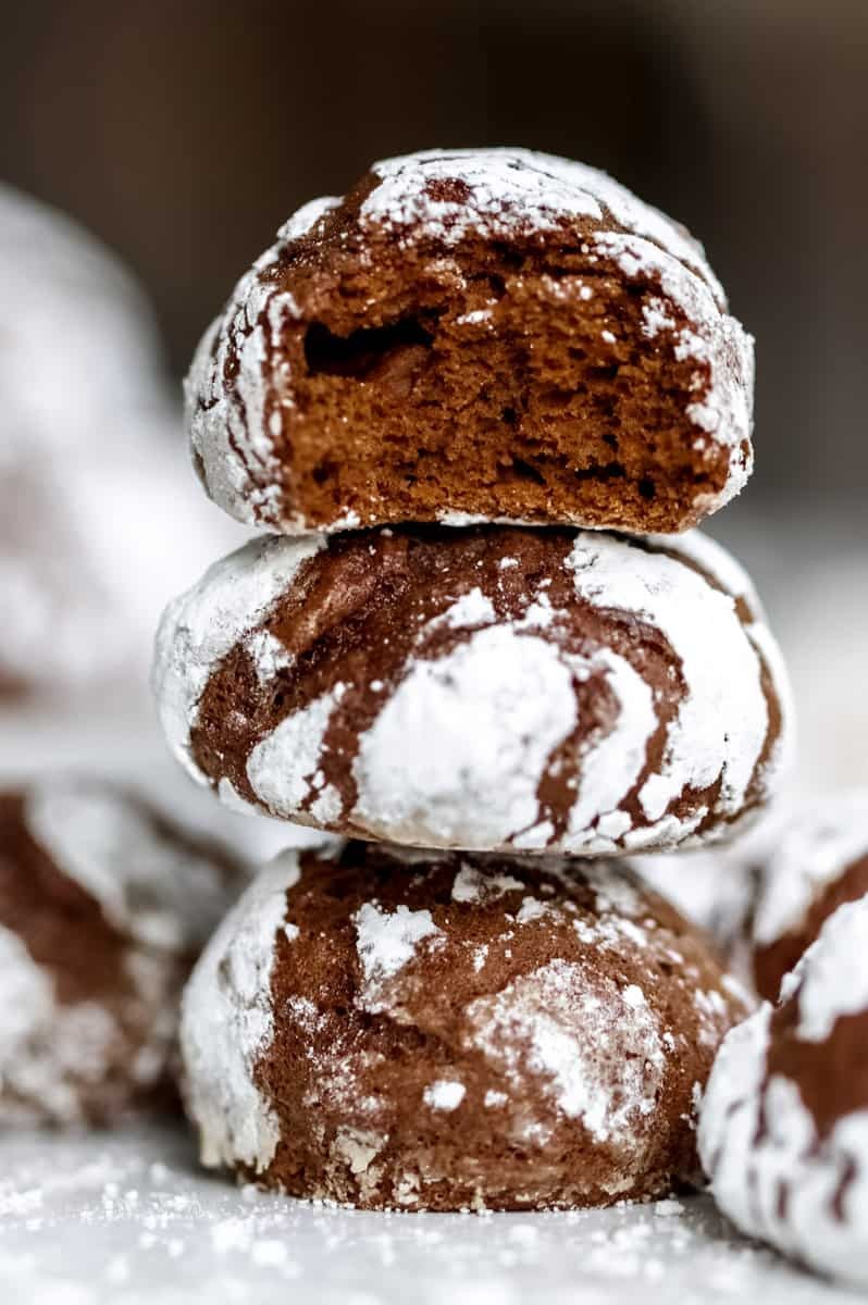 Pile of rich cocoa sugar cookies with powdered sugar dusting on a vintage plate, cozy kitchen background