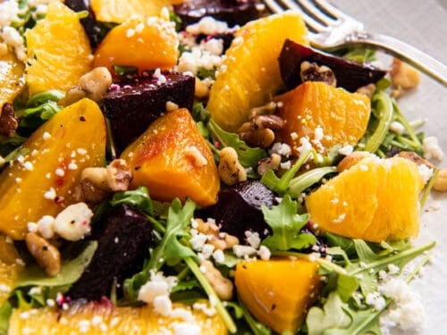 vibrant roasted beet salad with orange slices and feta cheese on a rustic wooden table
