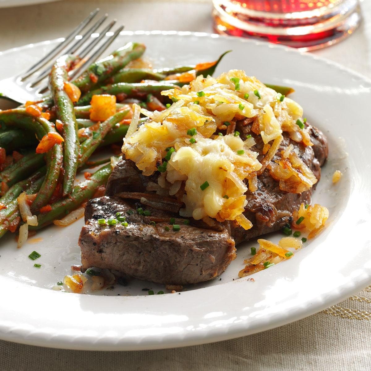 steak with hash browns on a plate, restaurant setting