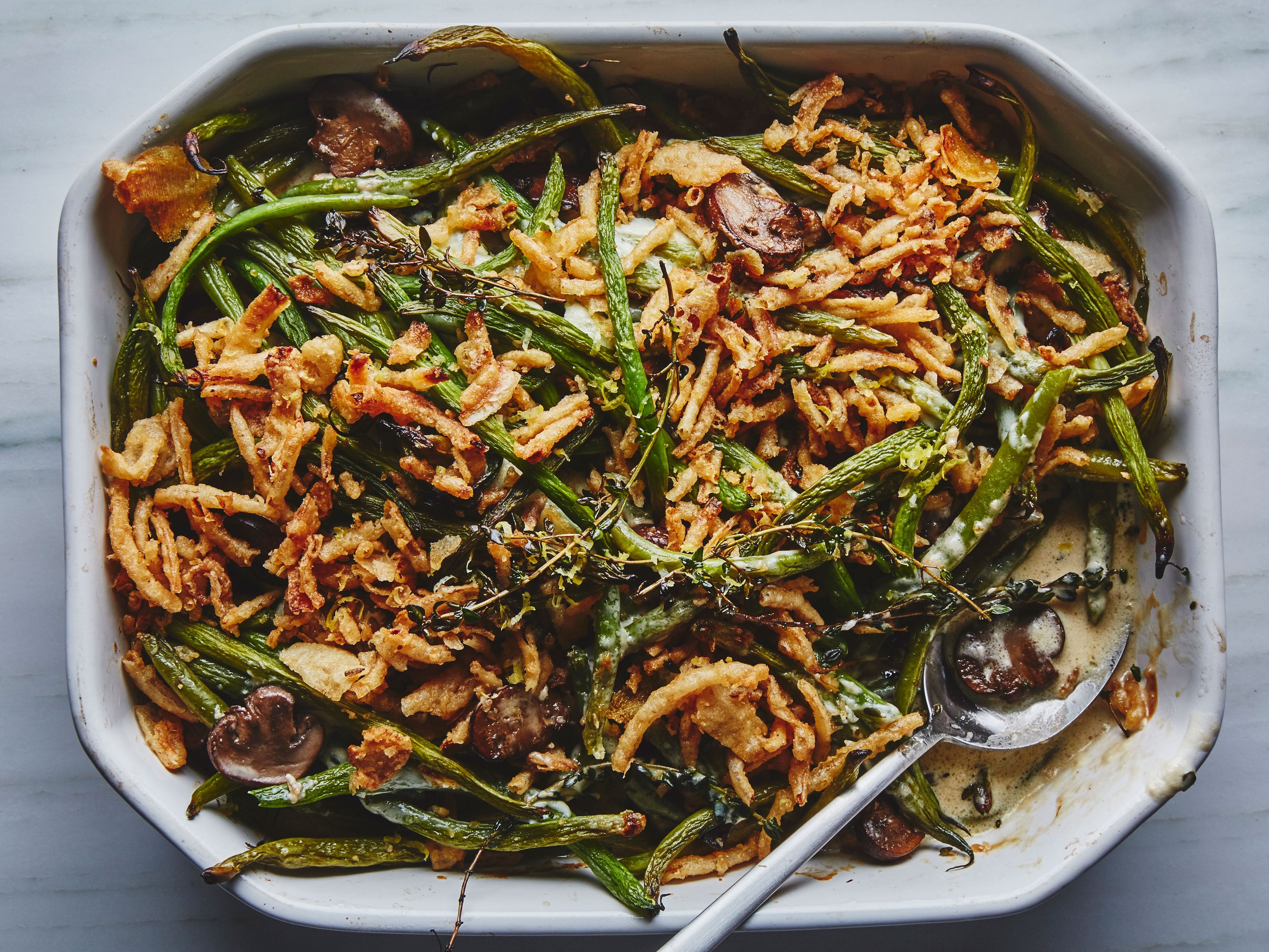 Homemade green bean casserole with golden crispy onion and buttery crumb topping, close-up, warm, rustic