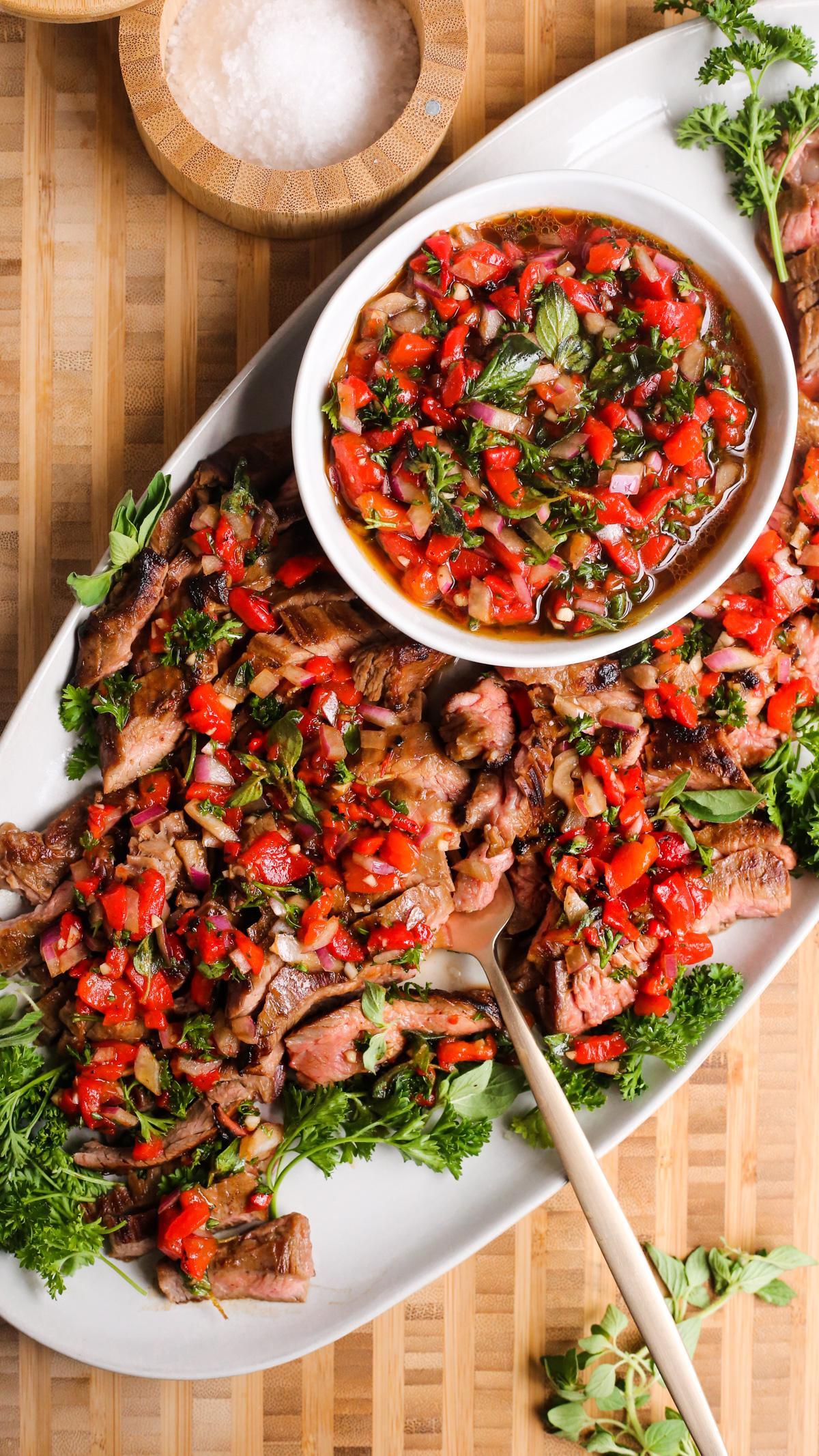 grilled steak with roasted red pepper sauce and herbs